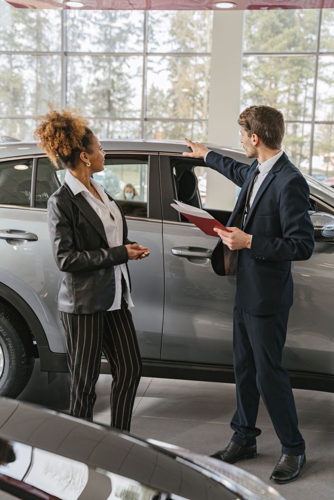 A woman and a car salesperson discussing vehicle options inside a dealership