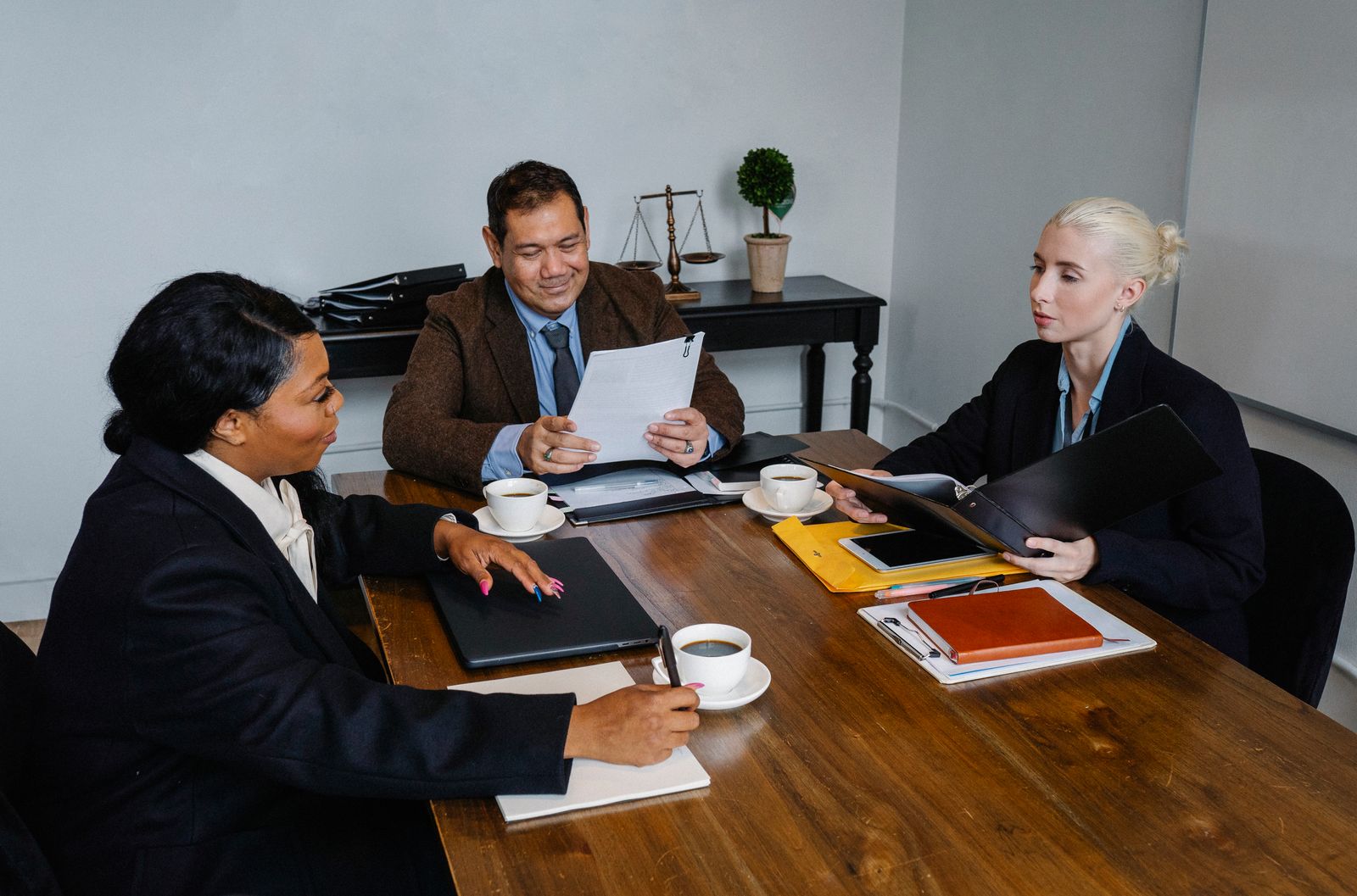Diverse sales team discussing documents around an office table