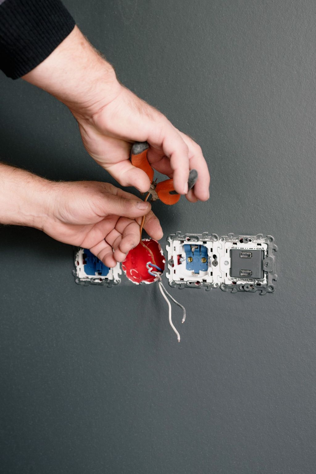 Electrician wiring a wall outlet