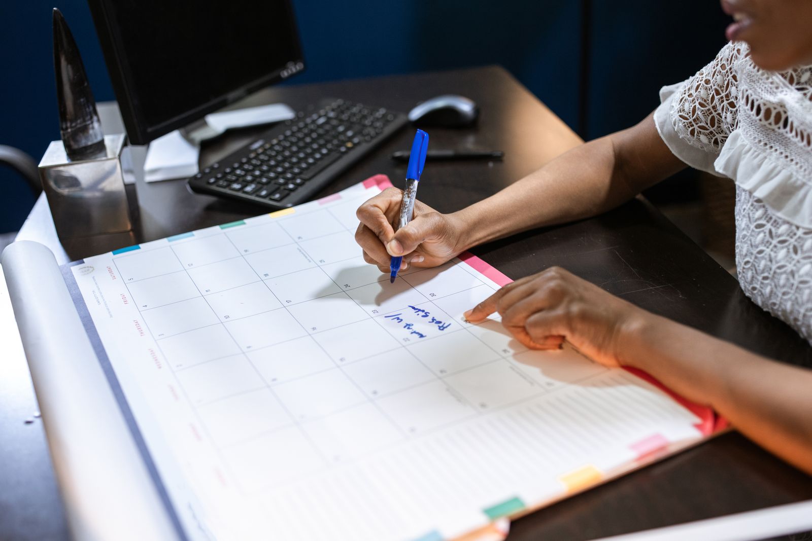 Person writing appointments in a desk calendar