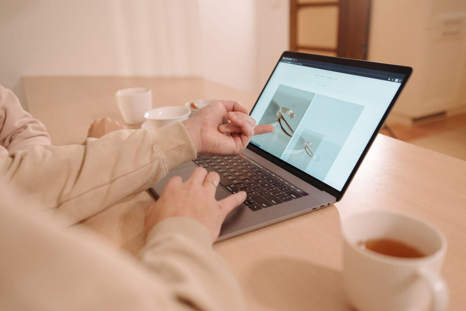 Two people working together at a laptop, one pointing at the screen
